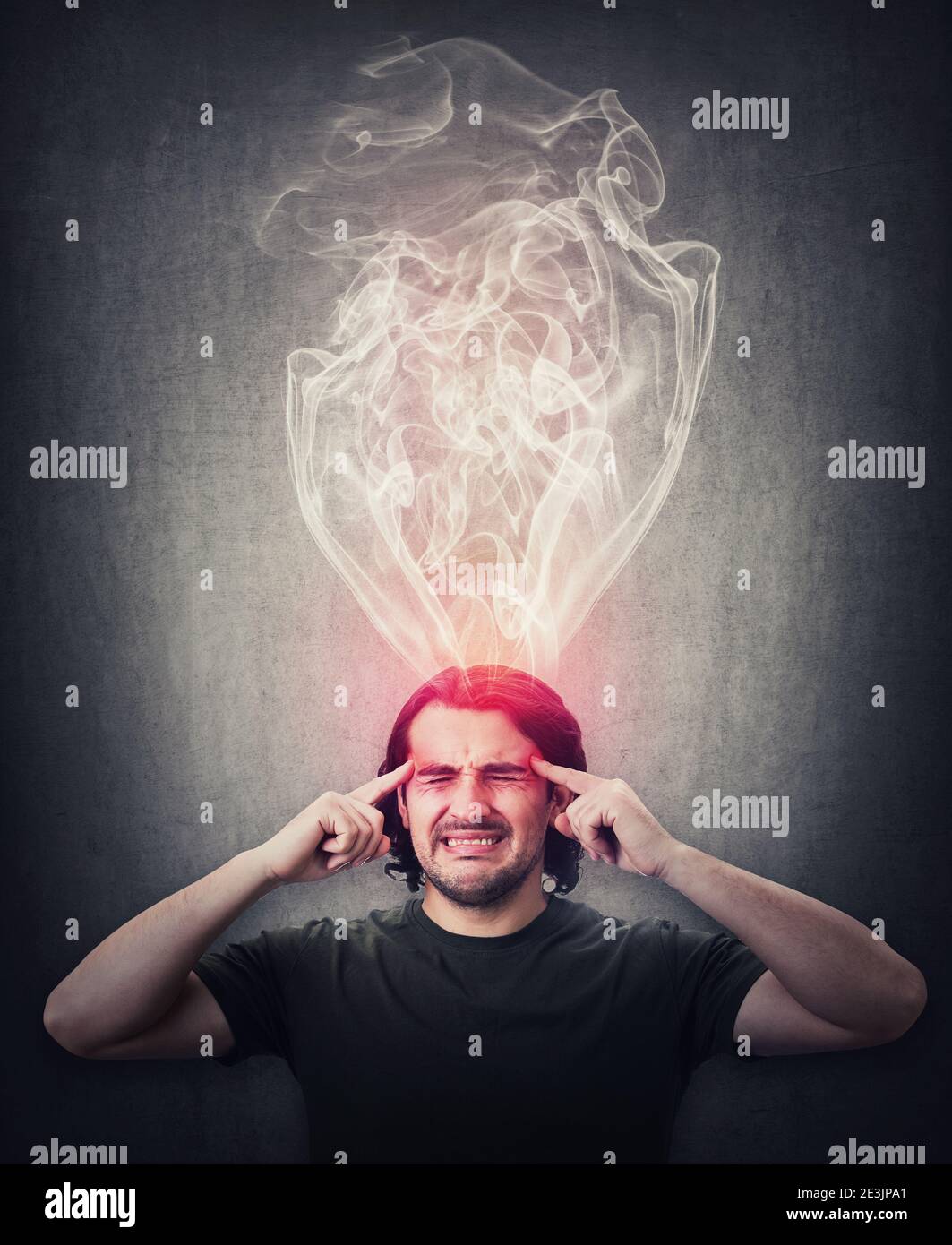 Fatigue and annoyed man, keeps fingers to his temples, feels like mind is boiling as dense steam comes out of his head. Brain burning and mental explo Stock Photo