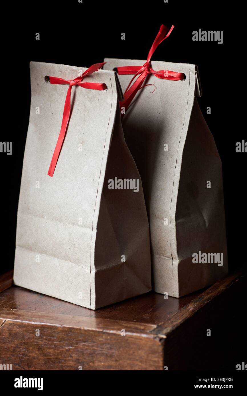 Zero waste kraft paper bags with red laces on wooden table on moody