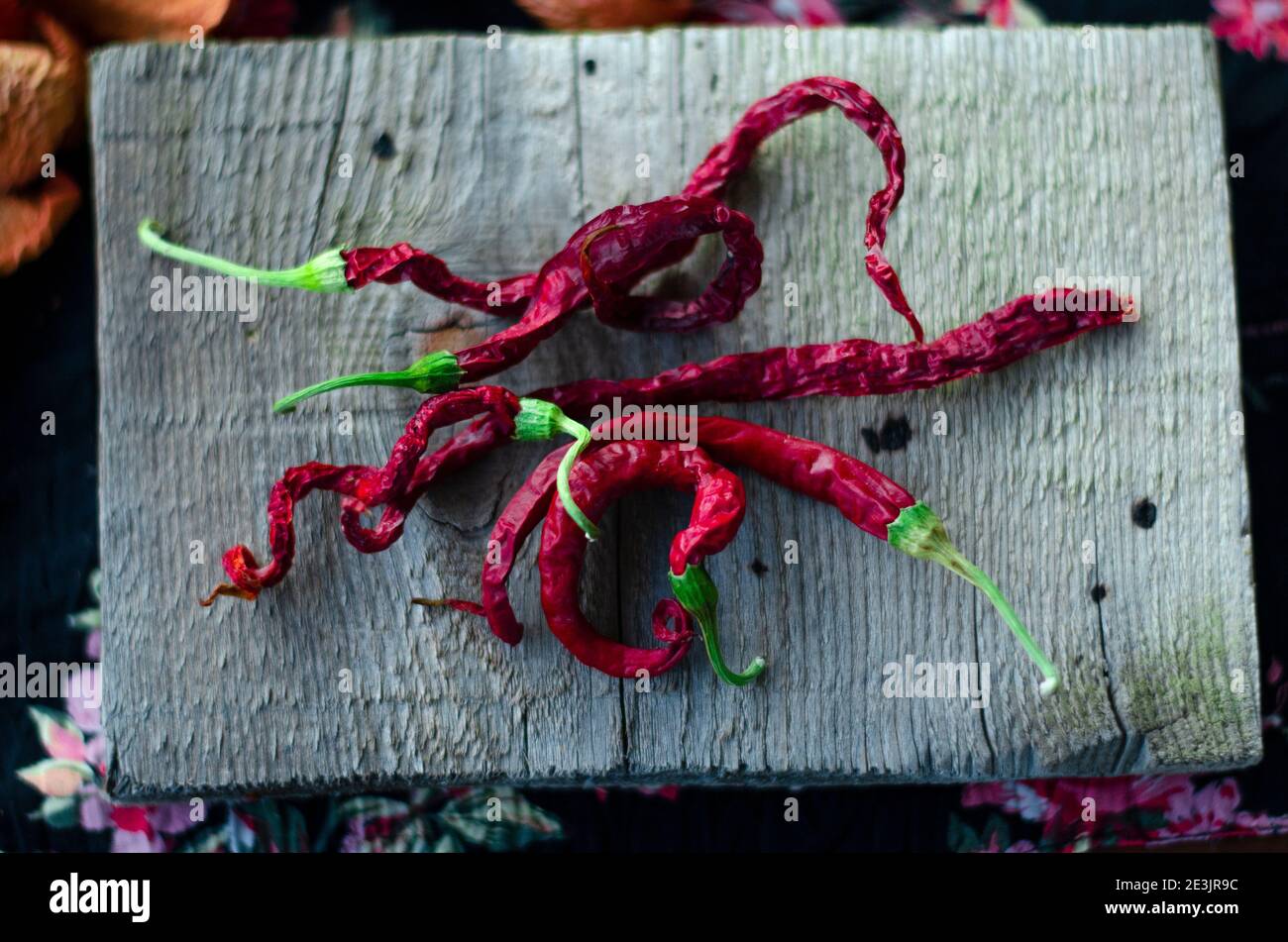 chilli red spicy peppers on a natural wooden plate Stock Photo - Alamy