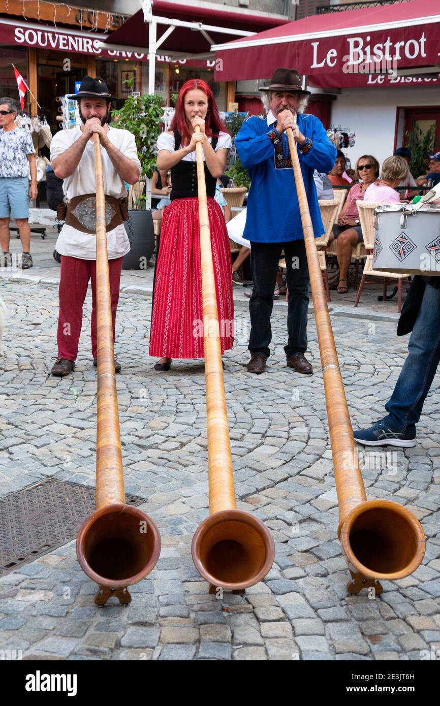 BOURG-SAINT-MAURICE, FRANCE - AUGUST 19, 2018: Musicians play alphorn, entertaining tourists and local people during traditional Agricultural and Moun Stock Photo