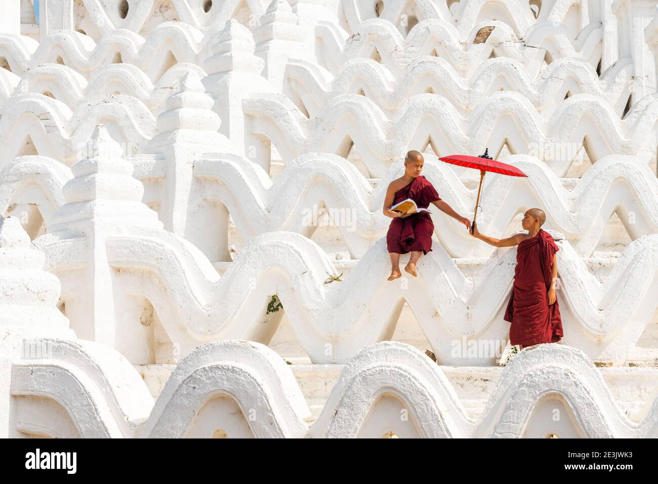 Novice monk giving umbrella to another novice monk at Hsinbyume pagoda, Mingun, Mandalay, Sagaing Township, Sagaing District, Sagaing Region, Myanmar Stock Photo