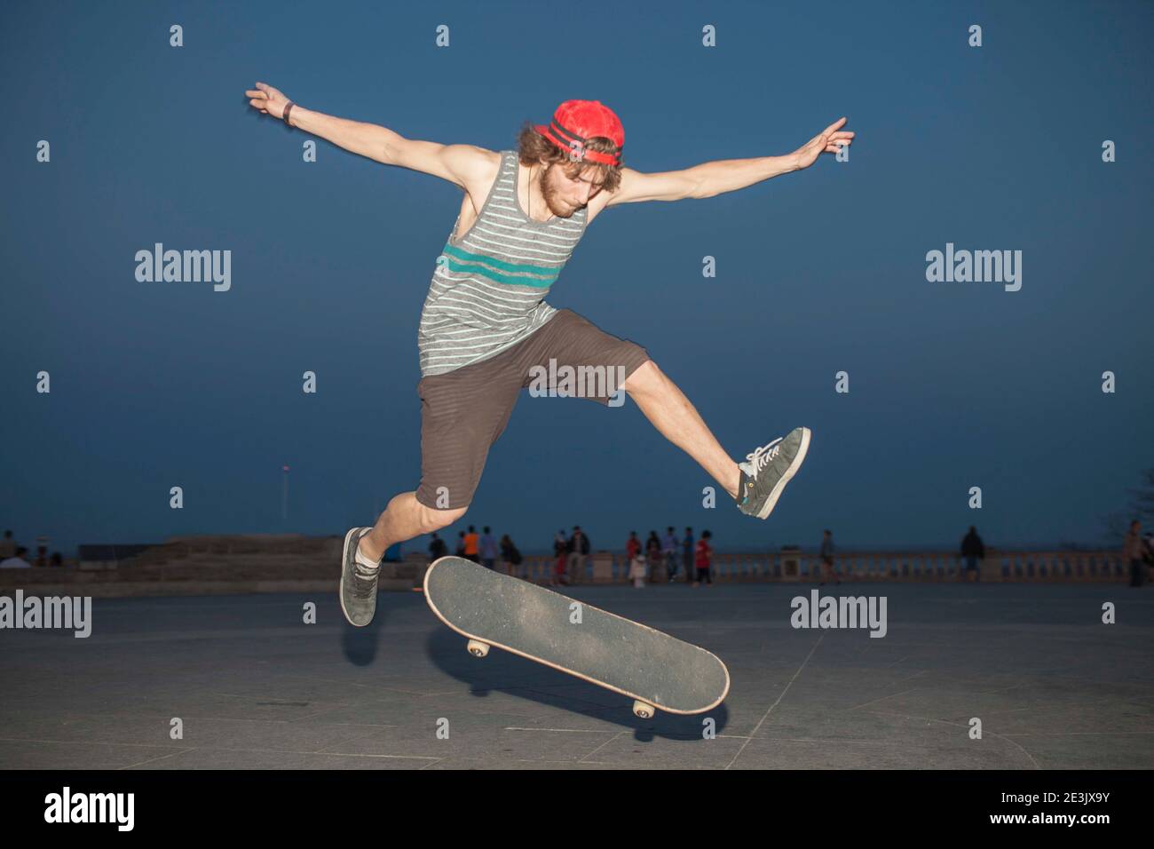 Young skateboard enthusiast flpping his board at night Stock Photo