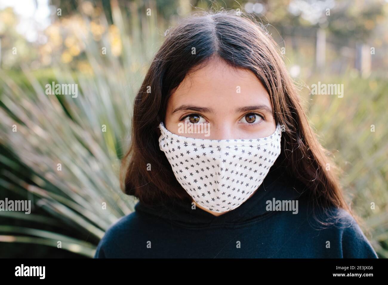 Portrait Of A Tween Girl Wearing A Cloth Face Mask With A Star Pattern