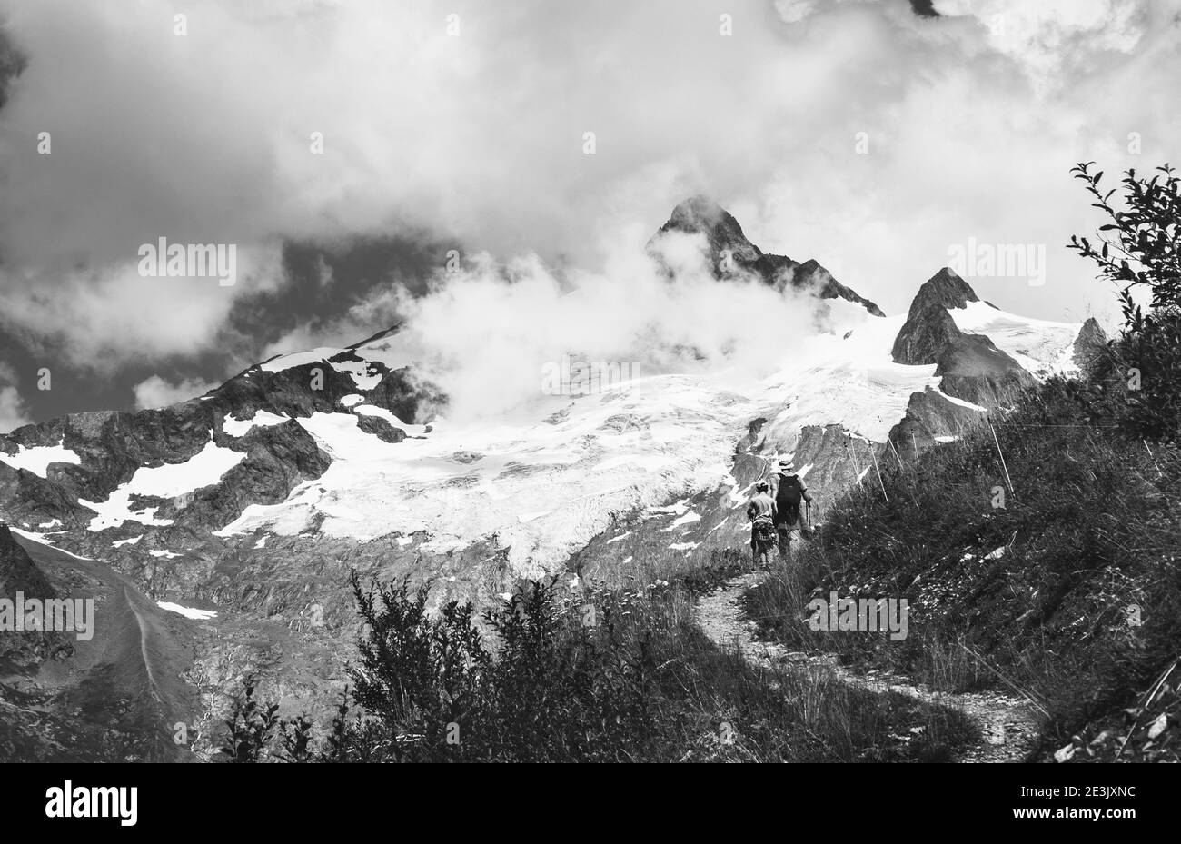 Father and son hiking in French Alps in summer. The Aiguille des Glaciers, mountain in the Mont Blanc massif. View From Chapieux valley, Savoie, Franc Stock Photo