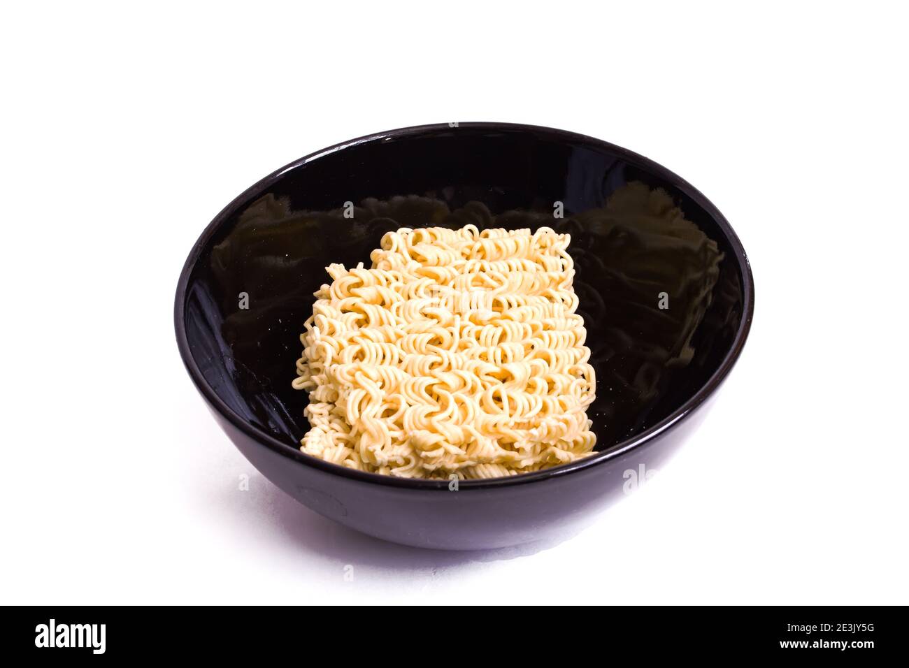 Thin egg noodles in black bowl isolated on a white background Stock