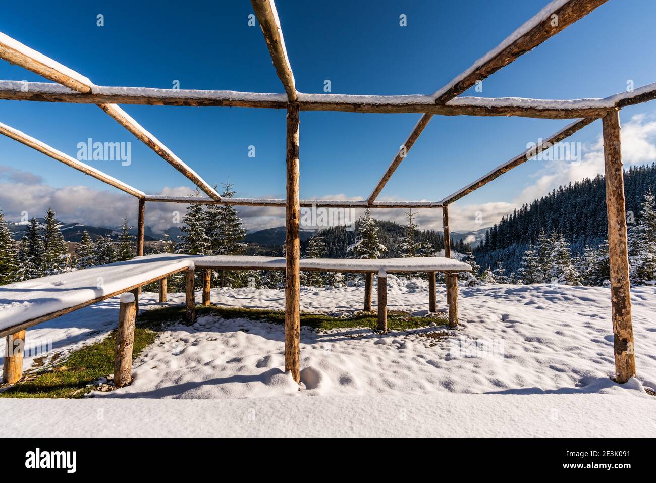 A large, uncovered gazebo on the top of the mountain stands on a snow ...