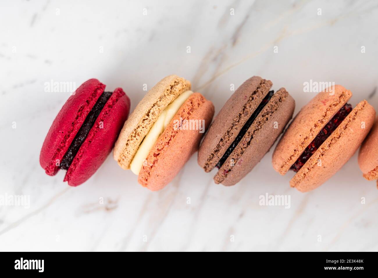 Colorful Fruity Macarons Flat Lay and Top View on White Marble Table Stock Photo