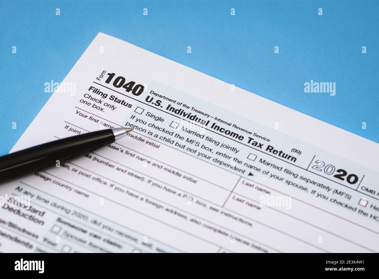 Close Up of Tax Form 1040 on Light Blue Background Stock Photo
