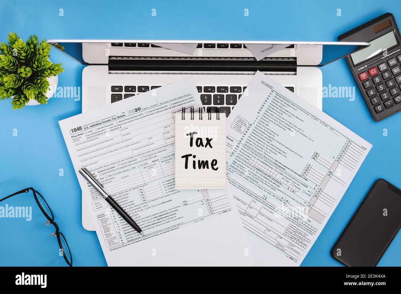 Tax Time. Tax Form 1040 on Office Desk on Light Blue Background Stock Photo