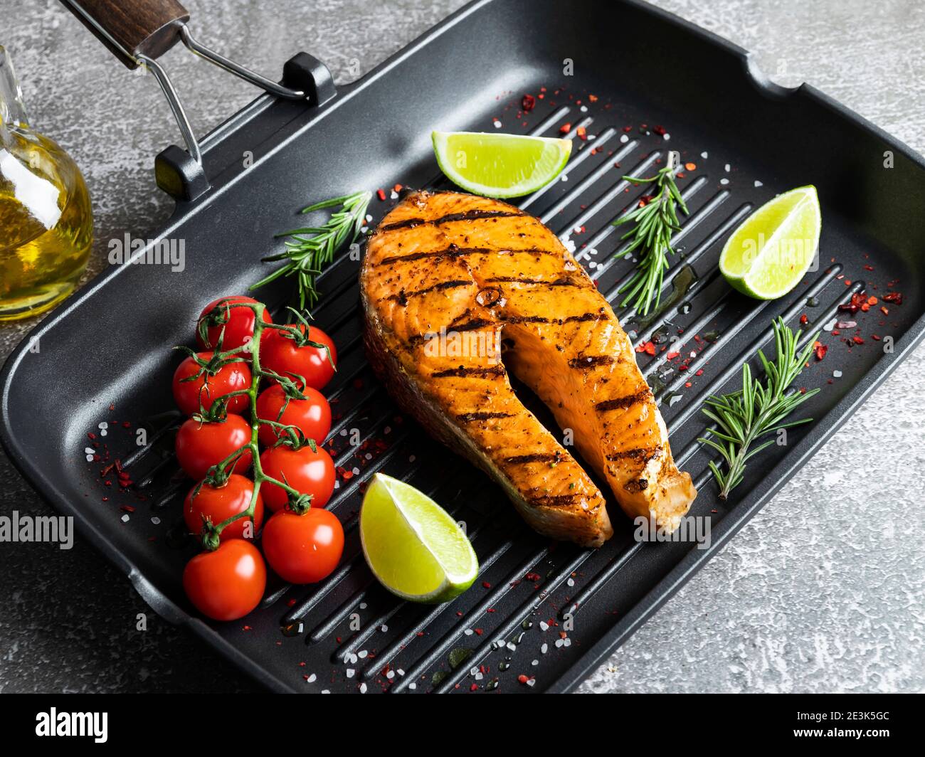 grilled steak fish salmon, trout in a grill pan, spices, rosemary, tomato Stock Photo