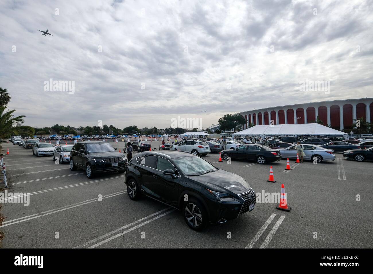Los Angeles, California, USA. 19th Jan, 2021. Motorists wait in lines to get the coronavirus (COVID-19) vaccine in a parking lot at the Forum, Tuesday, Jan. 19, 2021, in Inglewood, Calif. Los Angeles County is ramping up vaccination efforts in its battle against the coronavirus, opening 5 large-scale vaccine sites to complement 75 smaller locations and the city-operated center at Dodger Stadium. The new county centers are located at Six Flags Magic Mountain, Cal State Northridge, the Pomona Fairplex, the L-A County Office of Education in Downey and the Forum in Inglewood. L-A officials have Stock Photo
