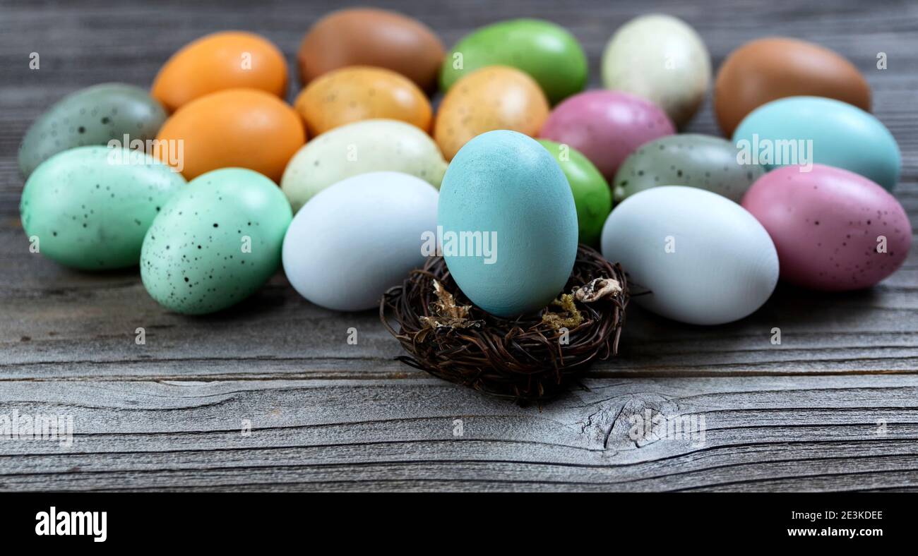 Select focus of a standing egg in nest with additional eggs and rustic wood in background Stock Photo
