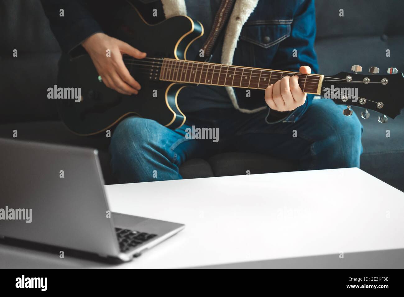 Teacher shows how to play the guitar. Remote online lesson Stock Photo