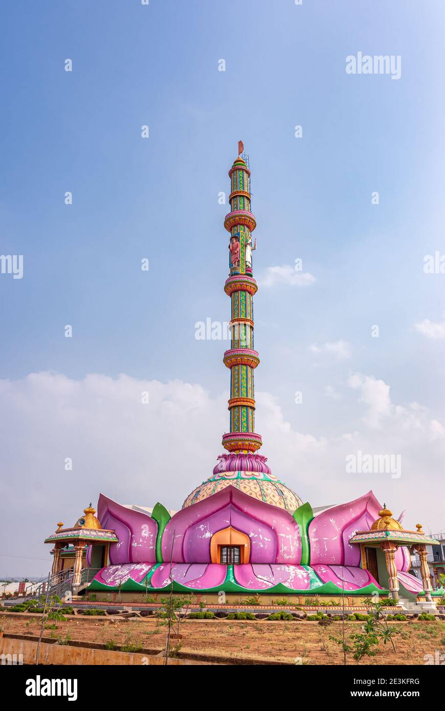 Hampi, Karnataka, India - November 5, 2013: Shree Shirdi Saibaba Sevashram spectacular and colorful building with slender tall tower reaching into blu Stock Photo