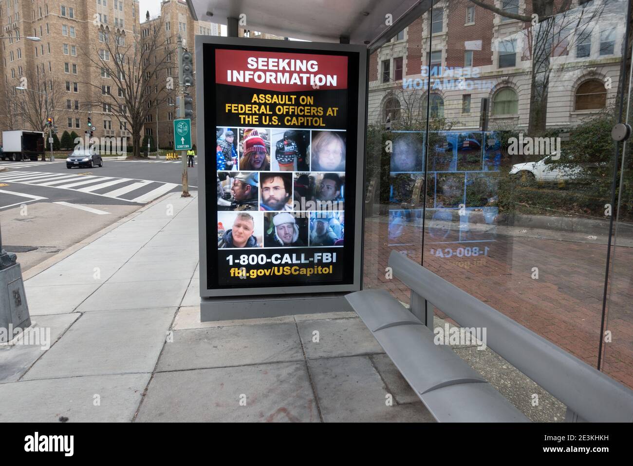 Digital sign at bus stop with rotating images of persons photographed during the storming of the U.S. Capitol on January 6, being sought by the Federal Bureau of Investigation. Washington, DC, Jan. 19, 2021 Stock Photo