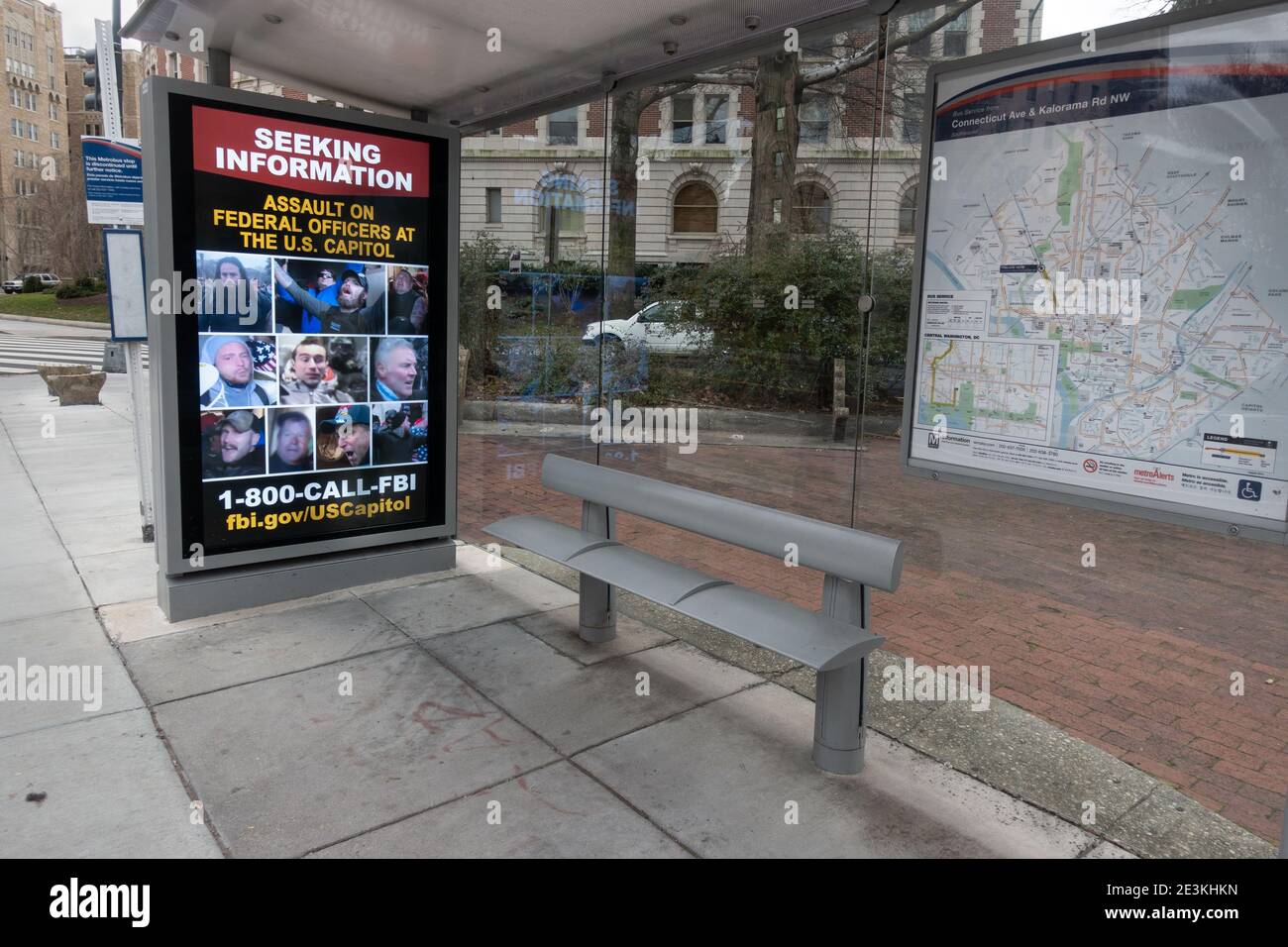 Digital sign at bus stop with rotating images of persons photographed during the storming of the U.S. Capitol on January 6, being sought by the Federal Bureau of Investigation. Washington, DC, Jan. 19, 2021 Stock Photo