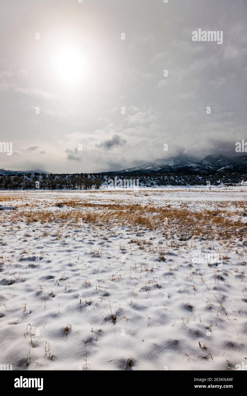 Clearing storm skies; fresh snow on pasture; central Colorado ranch; Salida; USA Stock Photo