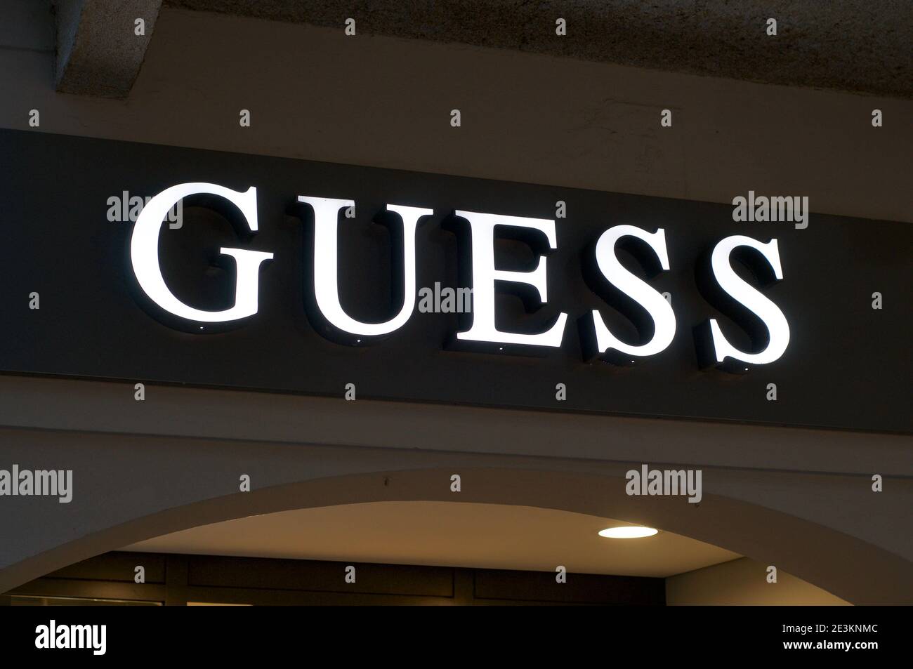 Lugano, Ticino, Switzerland - 14th January 2021 : Luminous Guess store sign hanging on the shop entrance in Lugano. Guess is an American clothing bran Stock Photo