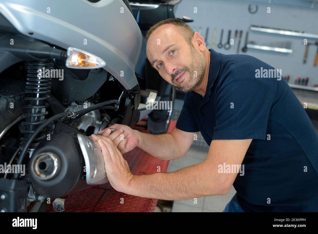 portrait of male mechanic working on scooter Stock Photo Alamy