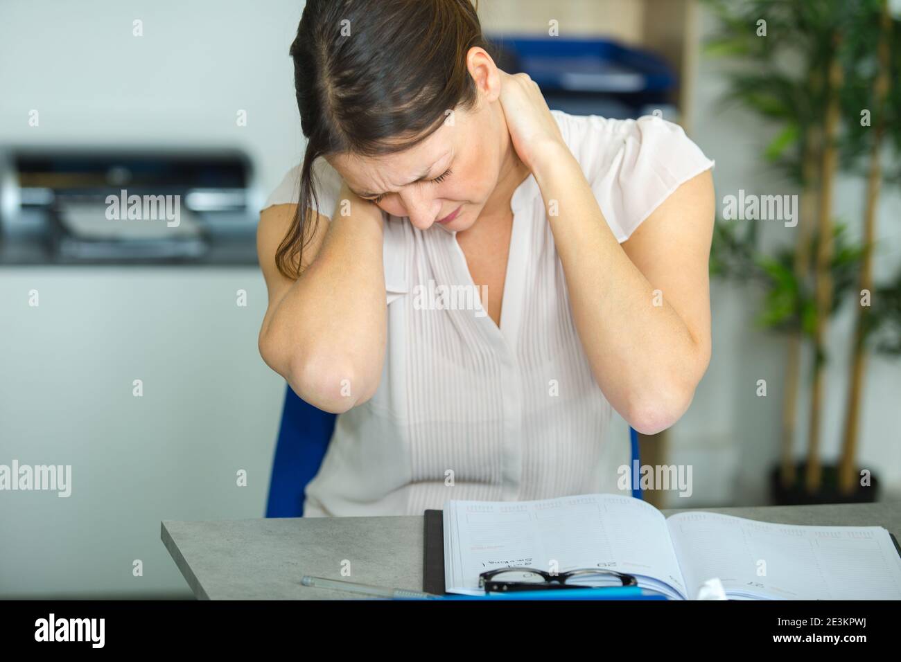 female office worker massaging aching neck Stock Photo
