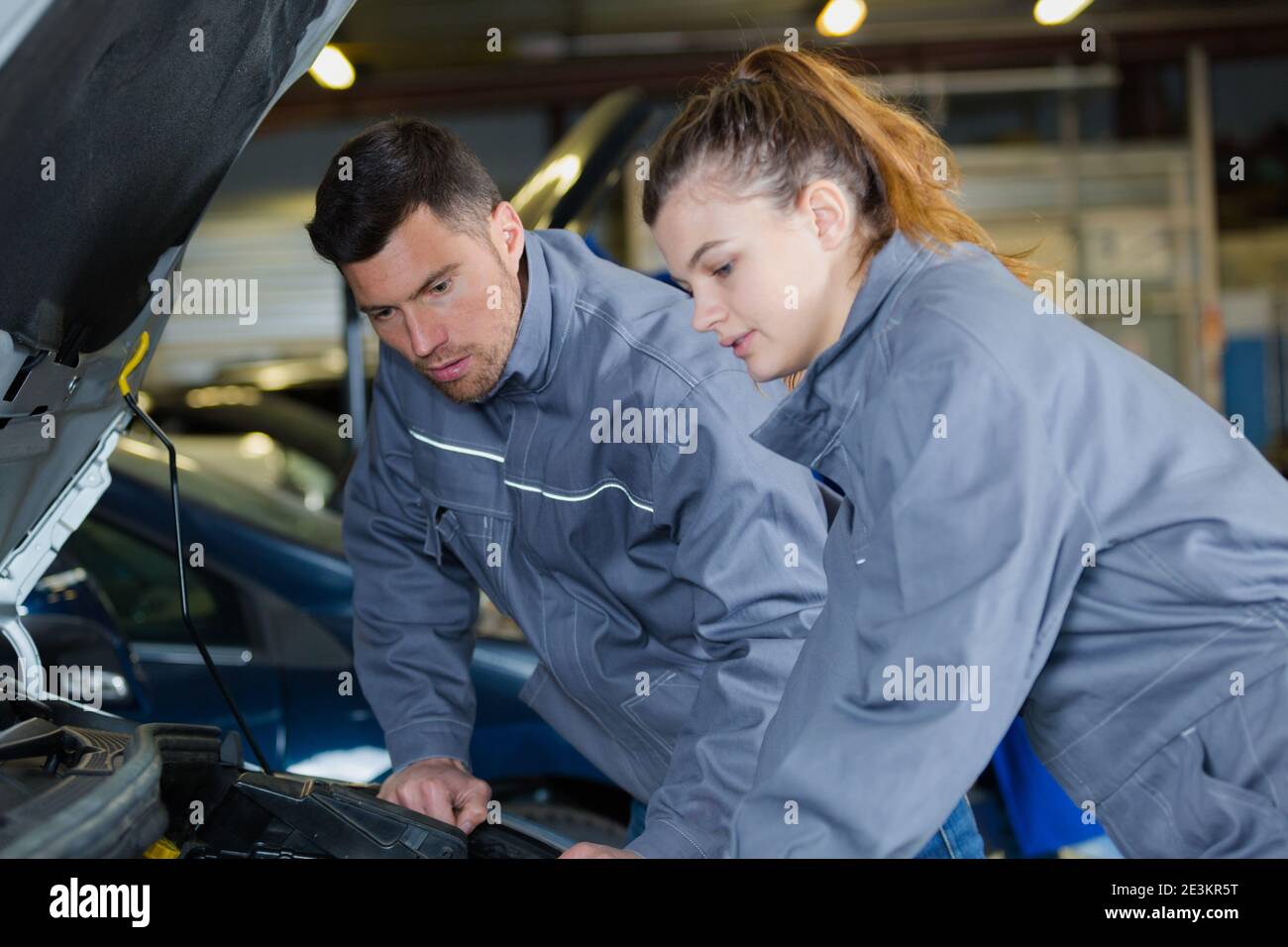 mechanic man and woman examine a car Stock Photo - Alamy