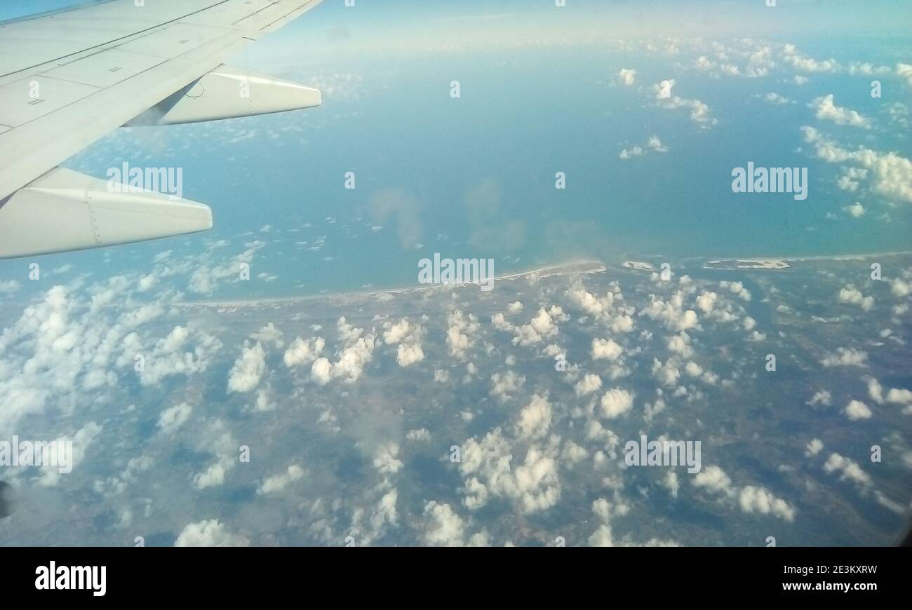 Aerial photography in Brazil. Earth surface viewed from airplane. Aerial view of the sky and the sea with clouds above earth. Stock Photo
