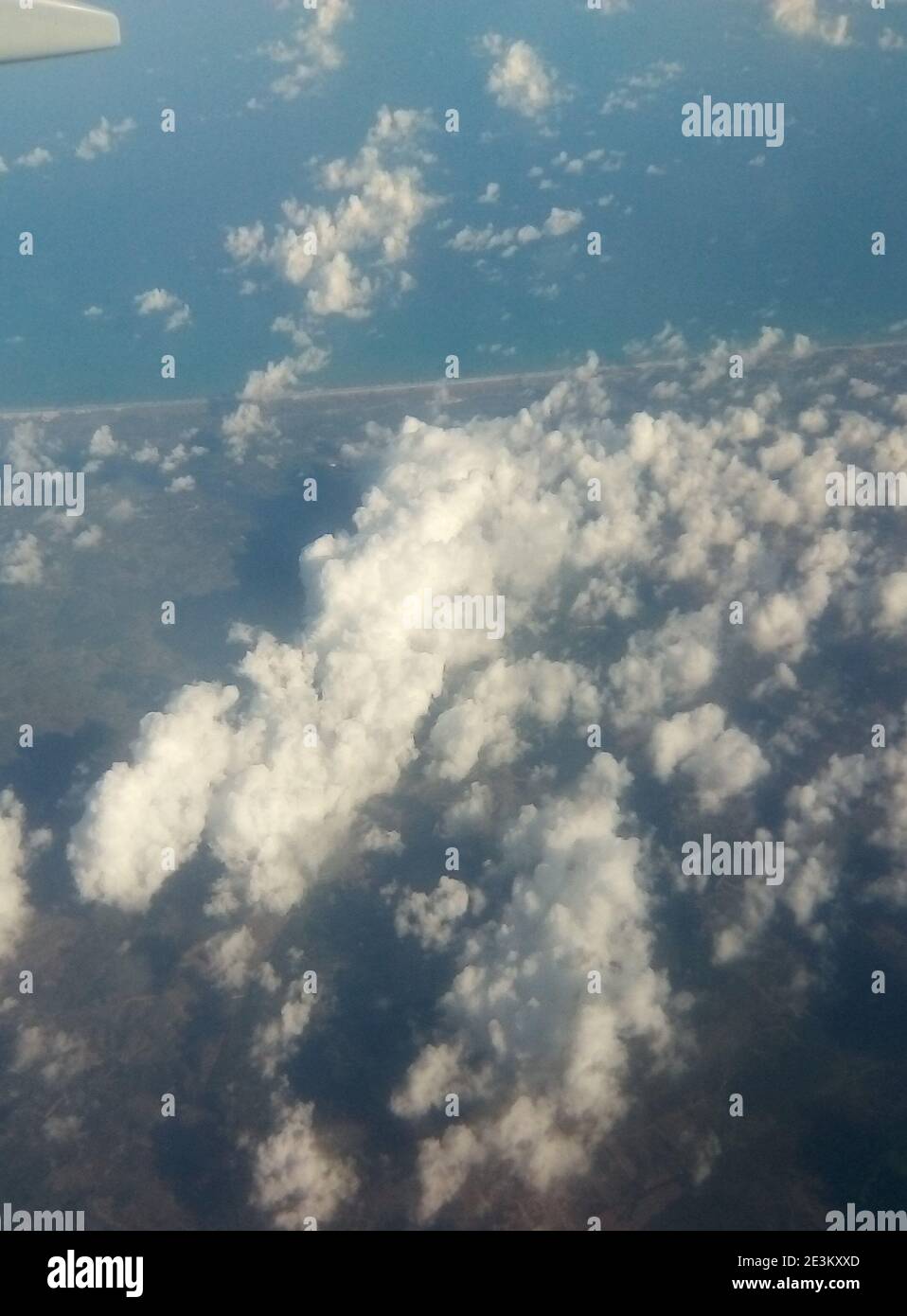 Aerial photography in Brazil. Earth surface viewed from airplane. Aerial view of the sky and the sea with clouds above earth. Stock Photo