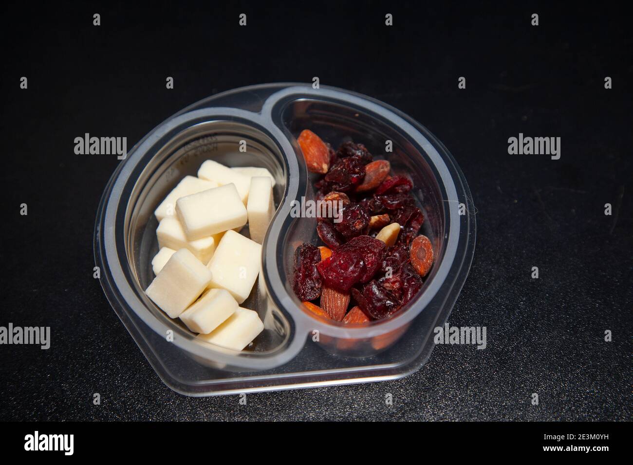 White cheddar cheese cubes, almonds, and dried cranberries in a plastic
