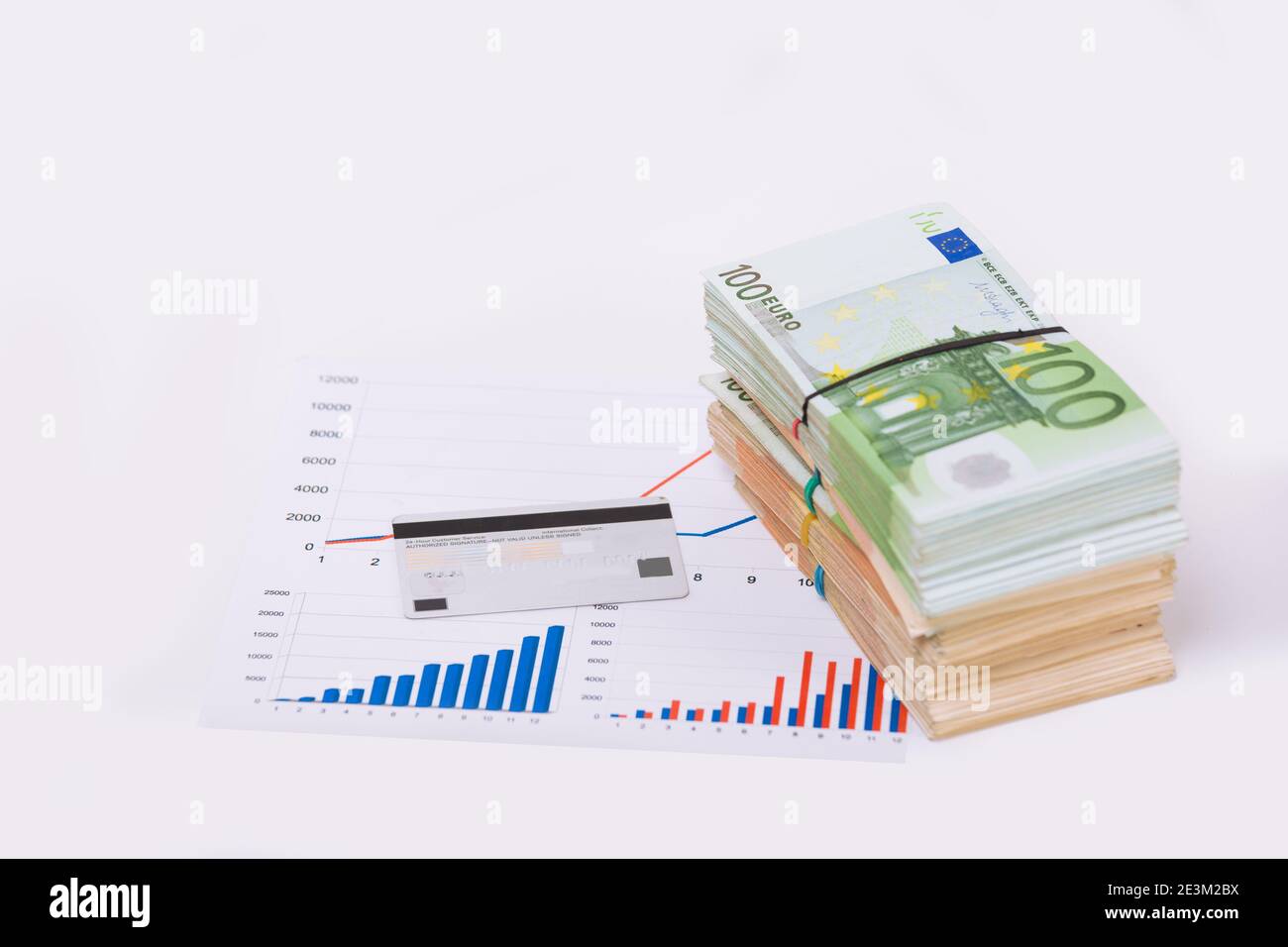Stack pile of european money, Euro cash currency on a graphic chart and a pen on it isolated on white background. Savings for a investing in stock mar Stock Photo