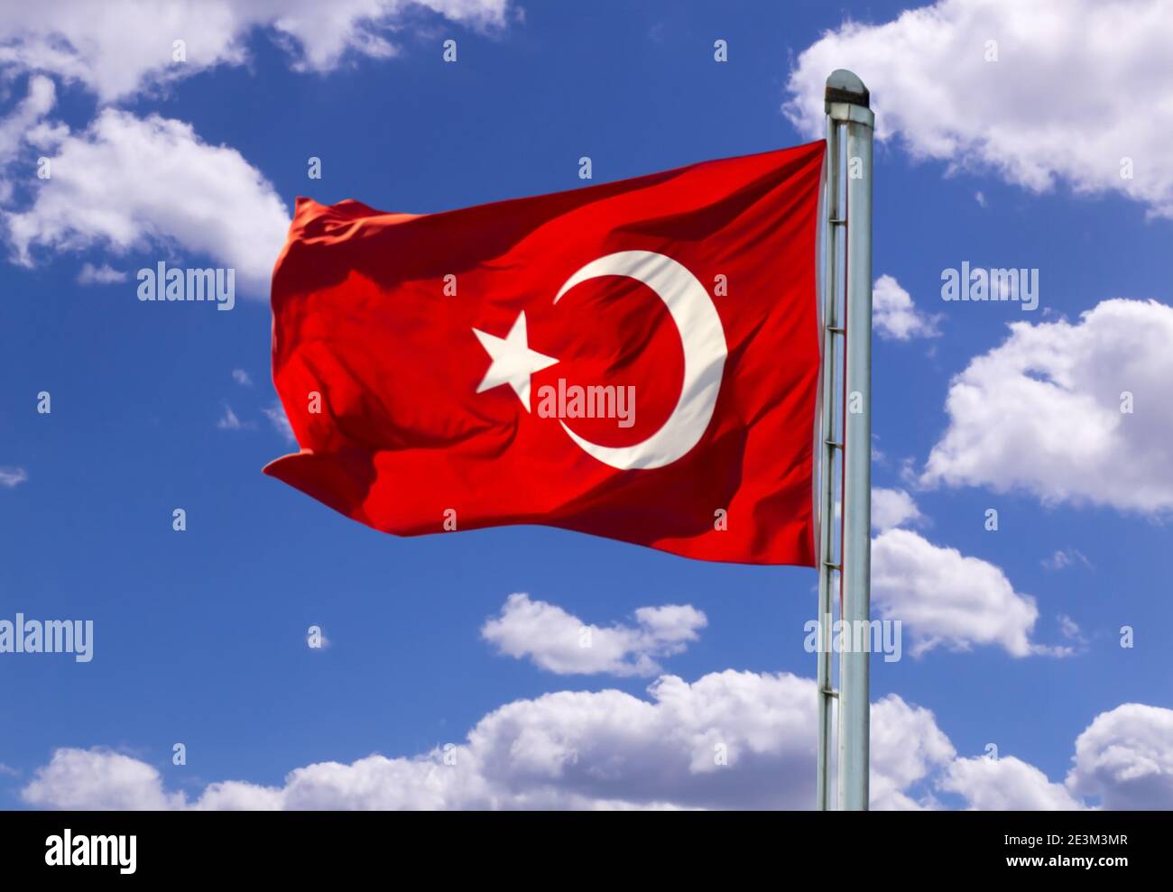 Waving red Turkish flag before blue sky with white clouds Stock Photo