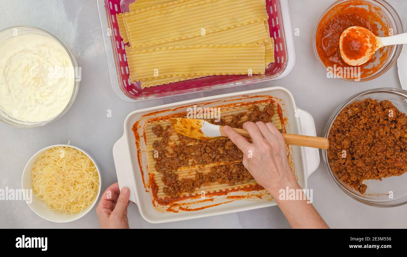 Beef lasagna step by step recipe. Assemble the lasagna. Woman hands