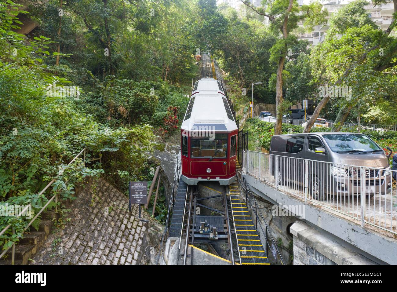 Victoria Peak Tram climbing up the steep hill, a Funicular Railway and Landmark of Hong Kong, Medium Shot Stock Photo