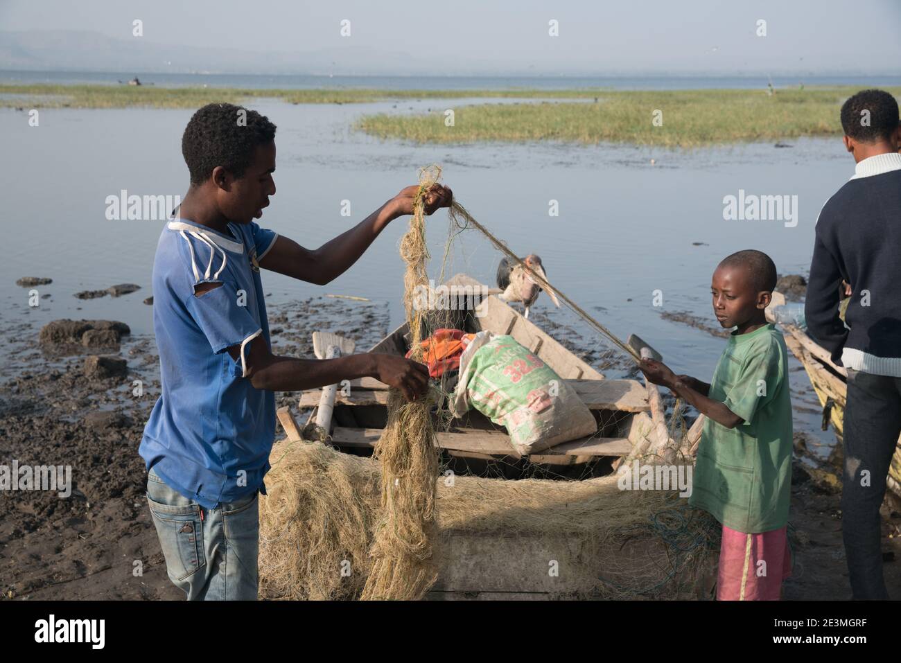 Fish Market at Lake Awasa: Young men and boys unravel and detangle fishing nets. Stock Photo