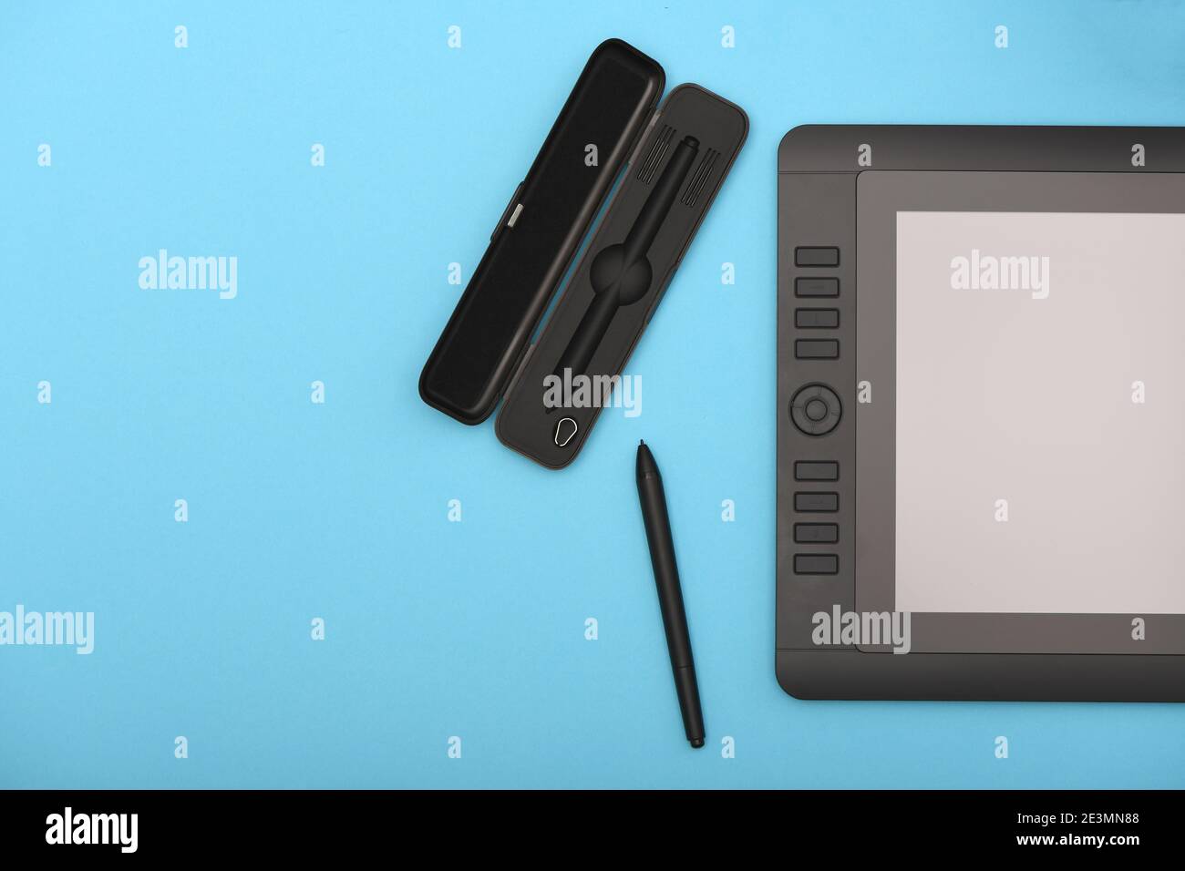 Graphic monitor stylus and glove on blue color table. Black tablet