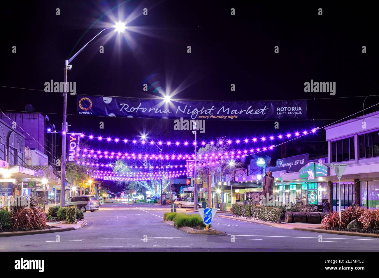 Rotorua, New Zealand, at night. Colorful lighting and a banner announcing the town's night market hangs over Tutanekai Street Stock Photo