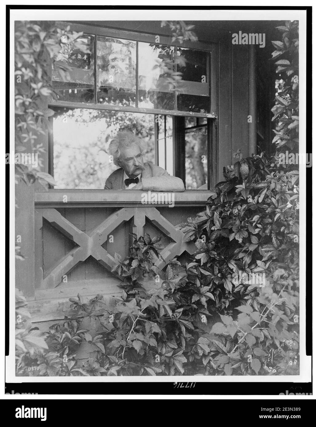 Mark Twain, head-and-shoulders portrait, facing slightly right, looking out window) - T.E. Morr Stock Photo