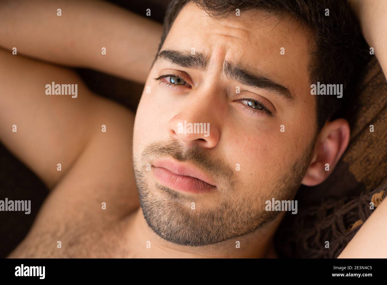 Closeup portrait of unshaven young guy in a hammock, looking at camera Stock Photo