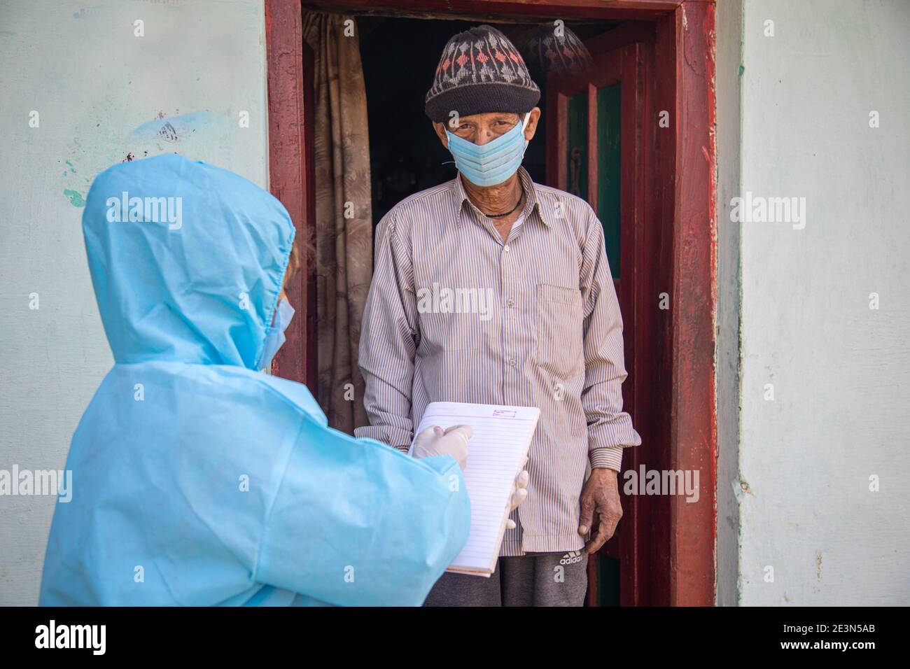 Women nurse workers in ppe kit doing door to door surveys in Indian village regarding Covid-19 Stock Photo