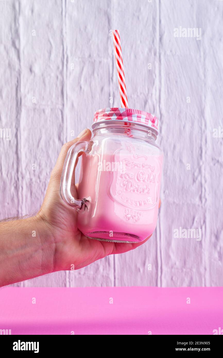 Cherry smoothie in a big glass cup with two straws in woman's hands,  isolated on white background. Lady with a drink Stock Photo - Alamy