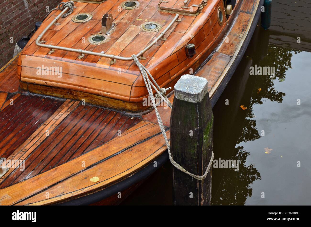 Old wooden boat tied to the pier Stock Photo - Alamy