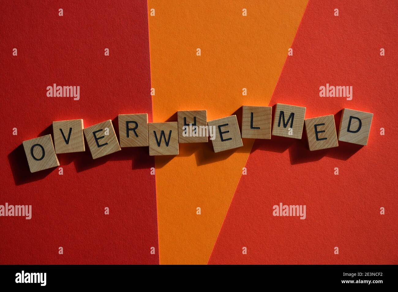 Overwhelmed, word in wooden alphabet letters isolated on orange and red background with copy space Stock Photo