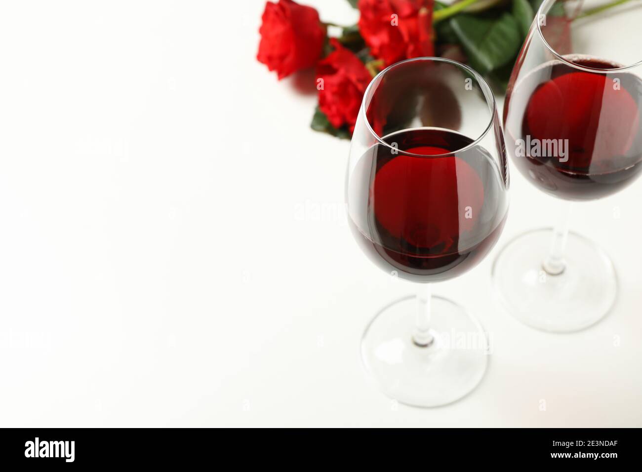 Red roses and glasses of wine on white background, space for text Stock ...