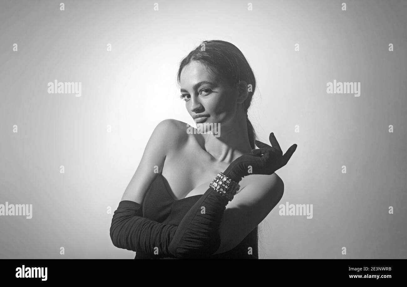 Sexy brunette woman in black dress and gloves. Big boobs Stock Photo - Alamy