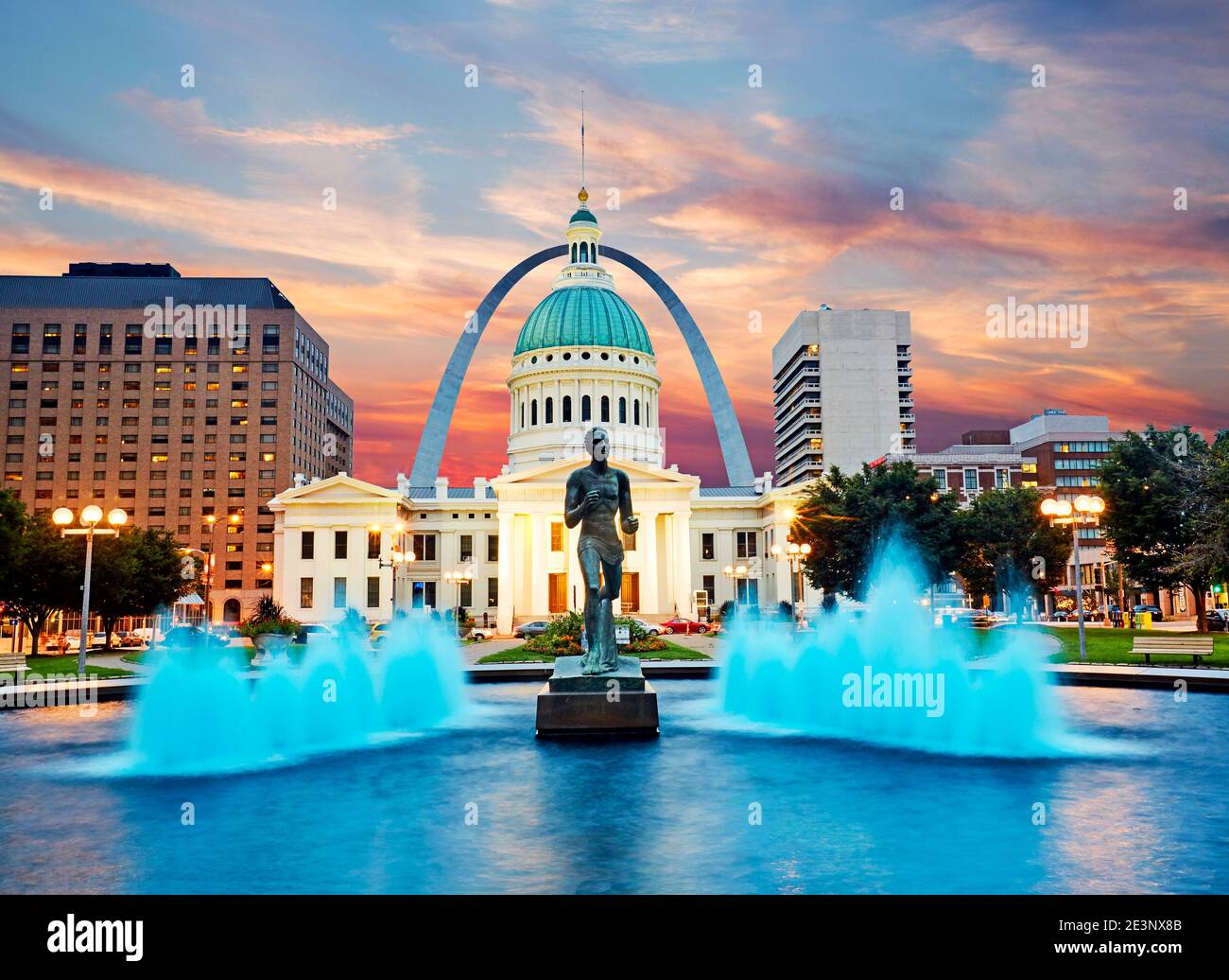 Old County courthouse and Runner sculpture in Downtown St Louis with Gateway arch at sunset Stock Photo