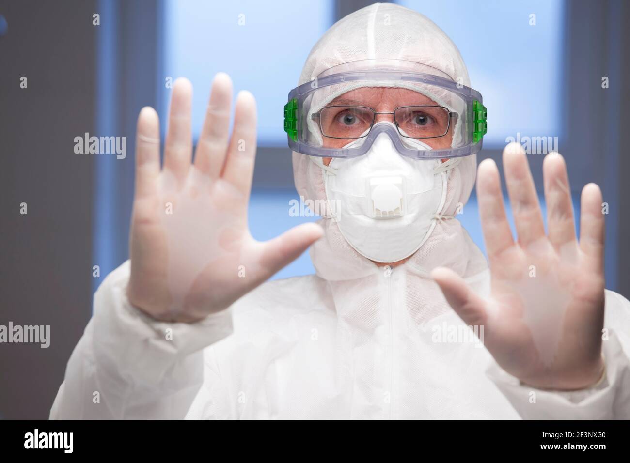Doctor or scientist with protective clothing gesturing stop for covid-19 - focus on the face Stock Photo