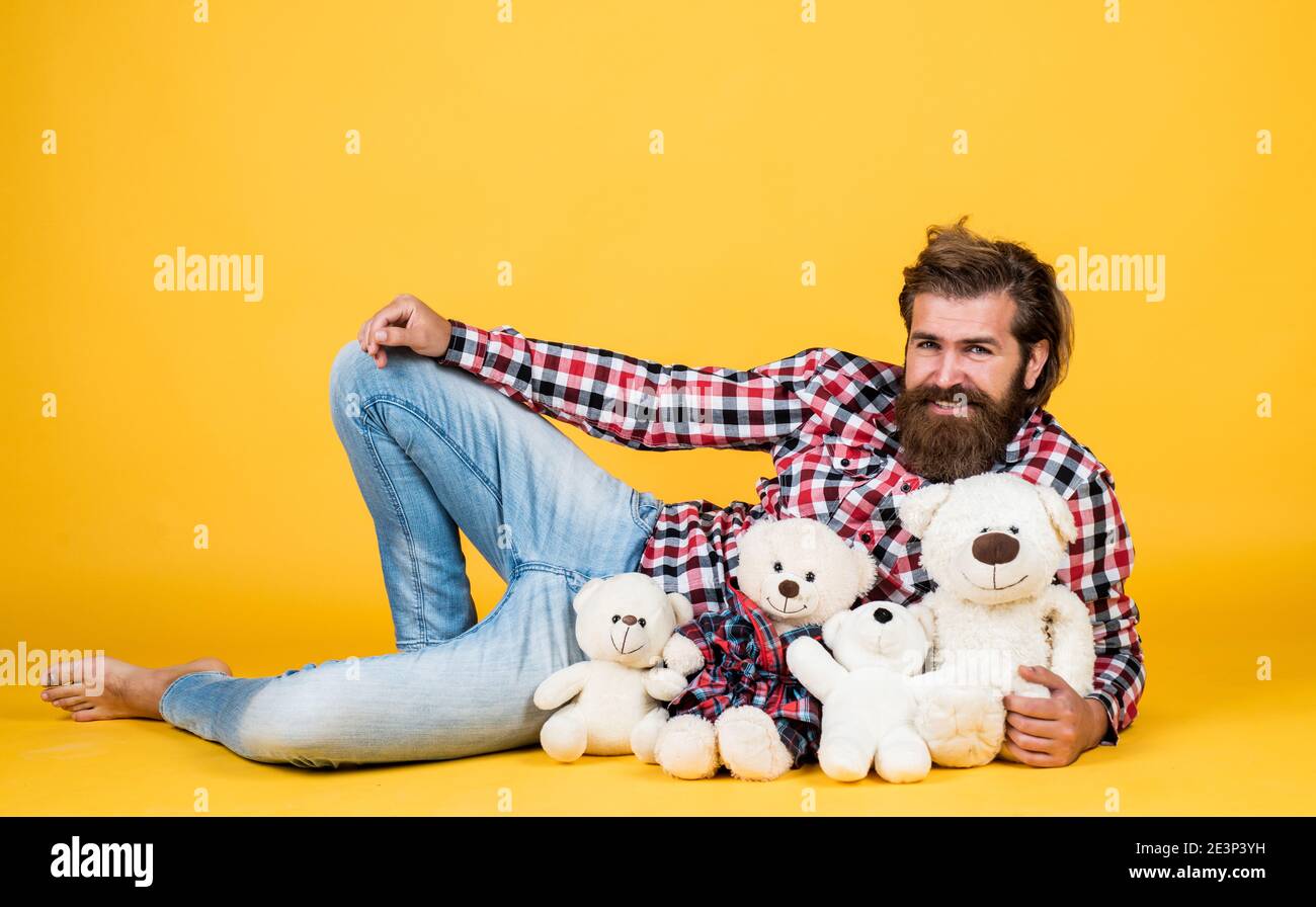 toy shop sales. Holiday celebration concept. Guy with happy face plays with soft toy. Childish mood concept. guy enjoy valentines day. best present ever. Valentines day gift for beloved. Stock Photo