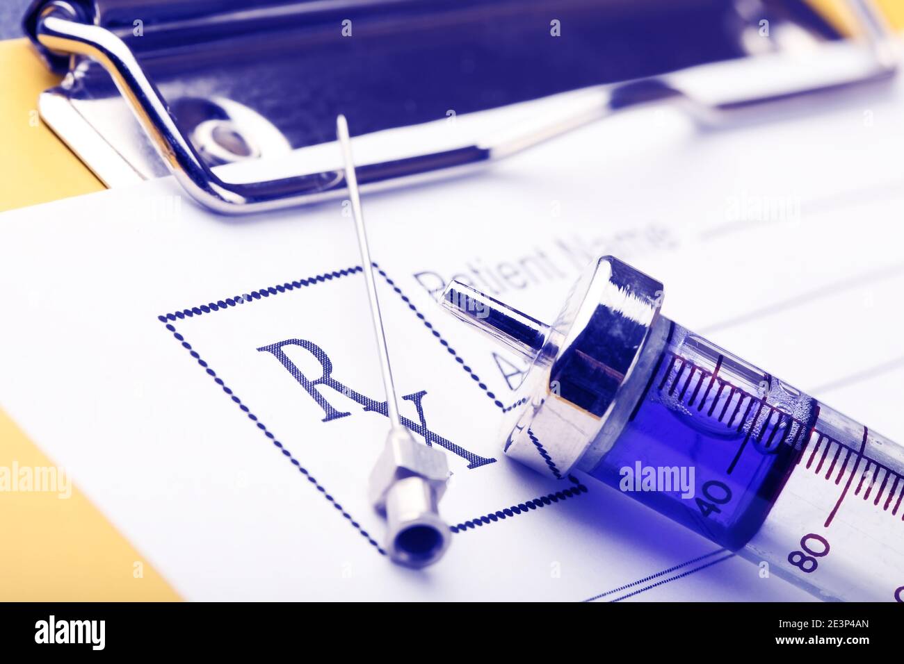 Prescription form and full with blue drug syringe close-up. Stock Photo
