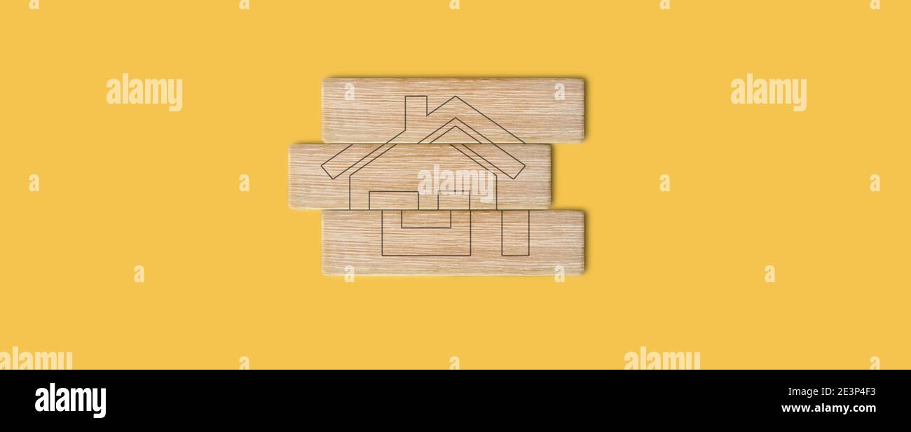 Conceptual image of home idea drawing in wooden blocks on yellow background - house accomplishment concept Stock Photo