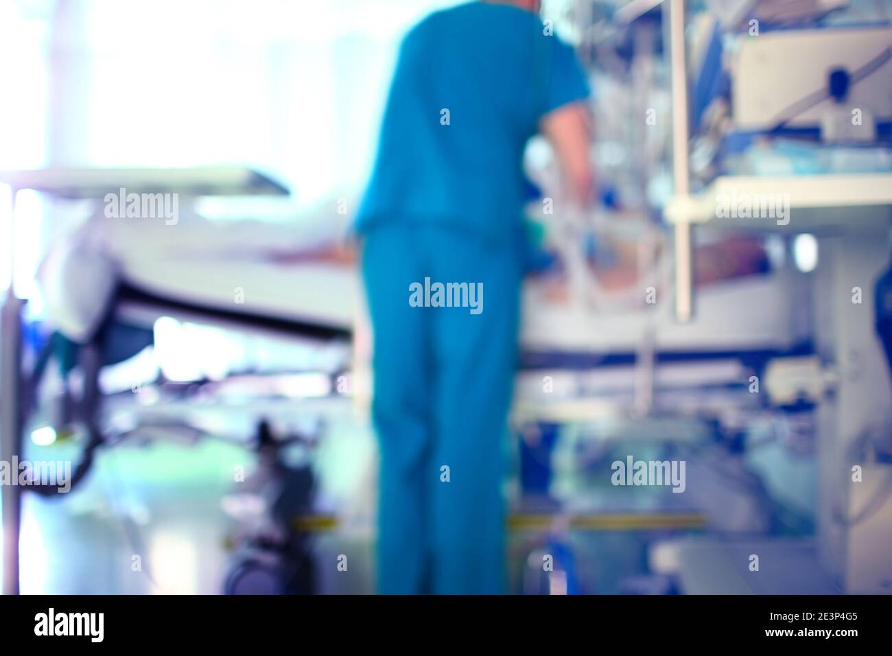 Silhouette of a working doctor at the patient bedside against the window, unfocused background. Stock Photo