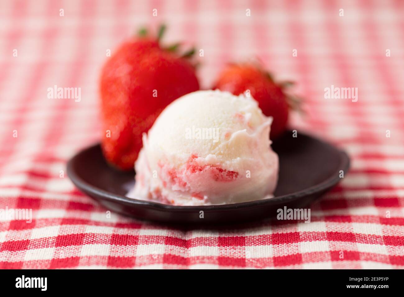 Homemade scoop of ice cream with strawberry fruit variegato and fresh strawberries Stock Photo